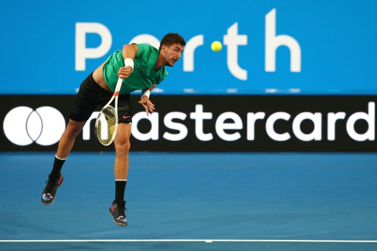 THANASI KOKKINAKIS of Australia serves in his singles match against David Goffin of Belgium in the 2018 Hopman Cup at Perth Arena in Perth, Australia.