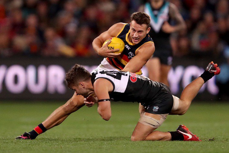 TOM DOEDEE of the Crows is tackled by SAM GRAY of the Power during the 2018 AFL match between the Port Adelaide Power and the Adelaide Crows at Adelaide Oval in Adelaide, Australia.