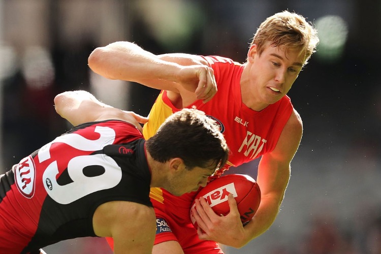TOM LYNCH of the Suns and PATRICK AMBROSE of the Bombers compete for the ball during the AFL match between the Essendon Bombers and the Gold Coast Suns at Etihad Stadium in Melbourne, Australia.