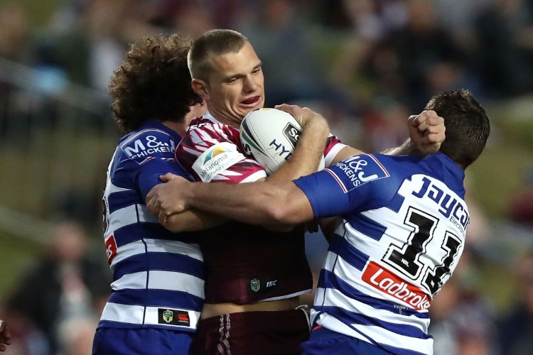 TOM TRBOJEVIC of the Sea Eagles is tackled during the NRL match between the Manly Sea Eagles and the Canterbury Bulldogs in Sydney, Australia.