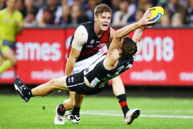 WILL HOSKIN-ELLIOTT of the Magpies takes a diving mark against Michael Hurley of the Bombers during the AFL match between the Collingwood Magpies and the Essendon Bombvers in Melbourne, Australia. WILL HOSKIN-ELLIOTT of the Magpies takes a diving mark against Michael Hurley of the Bombers during the AFL match between the Collingwood Magpies and the Essendon Bombvers in Melbourne, Australia.