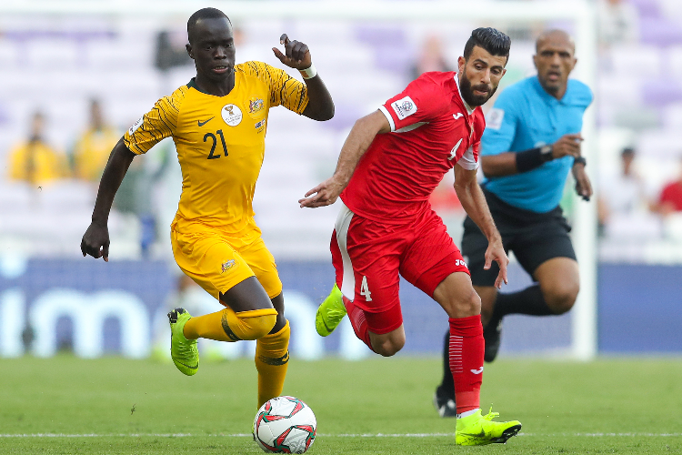 AWER MABIL of Australia competes for the ball with Baha' Abdel-Rahman of Jordan during the AFC Asian Cup Group B match between Australia and Jordan at Hazza Bin Zayed Stadium in Al Ain, United Arab Emirates.