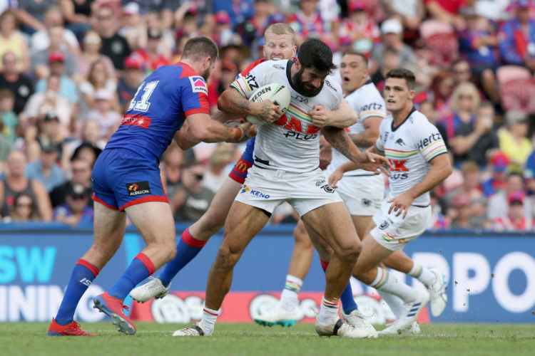 JAMES TAMOU of the Penrith Panthers is tackled by the Knights between the Newcastle Knights and the Penrith Panthers at McDonald Jones Stadium in Newcastle, Australia.