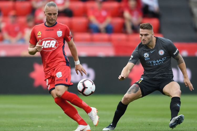 KEN LISO of Adelaide United competes with Bart Schenkeveld of Melbourne City during the A-League match between Adelaide United and the Melbourne City at Coopers Stadium in Adelaide, Australia.