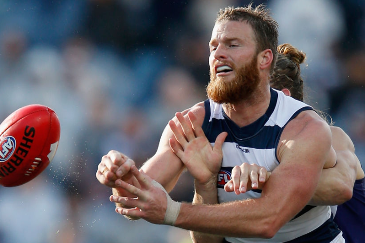 LACHIE HENDERSON of the Cats handballs during the AFL match between the Geelong Cats and the Fremantle Dockers at GMHBA Stadium in Geelong, Australia.
