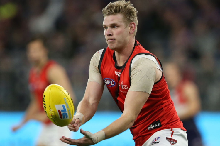 MICHAEL HURLEY of the Bombers handballs during the AFL match between the Fremantle Dockers and the Essendon Bombers at Optus Stadium in Perth, Australia.