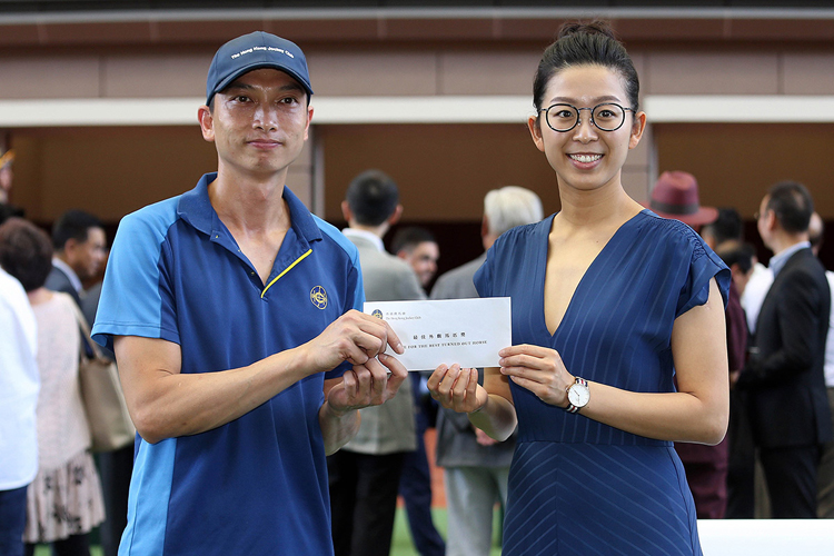 Three-time WWS The Women's World Snooker Championship Ng On-yee (right) presents the award for the Best Turned Out Horse prior to the running of the Hong Kong Reunification Cup race.