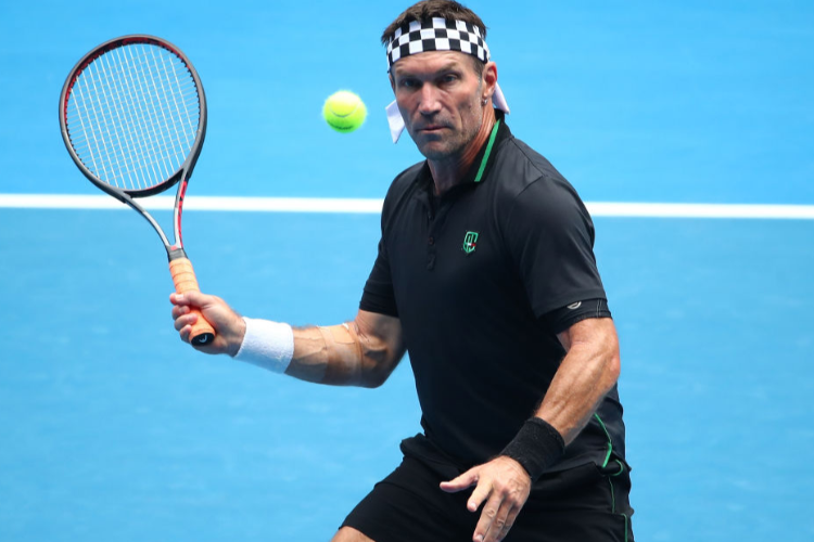 PAT CASH of Australia plays a forehand in his Legends Doubles match during the Australian Open at Melbourne Park in Melbourne, Australia.