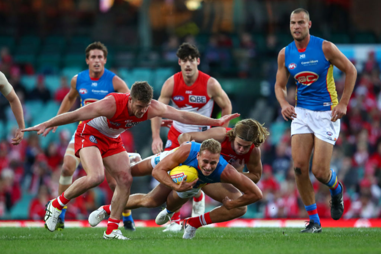WILL BRODIE of the Suns is tackled during the round 15 AFL match between the Sydney Swans and the Gold Coast Suns at Sydney Cricket Ground in Sydney, Australia.