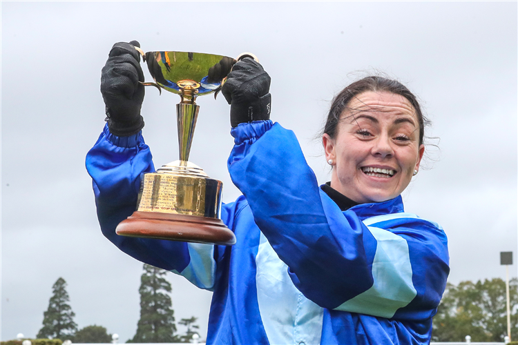 Rider Sam Wynne is full of smiles as she poses with the trophy secured by Neeson after his victory in the Seaton Family Memorial Hororata Gold Cup (1800m)