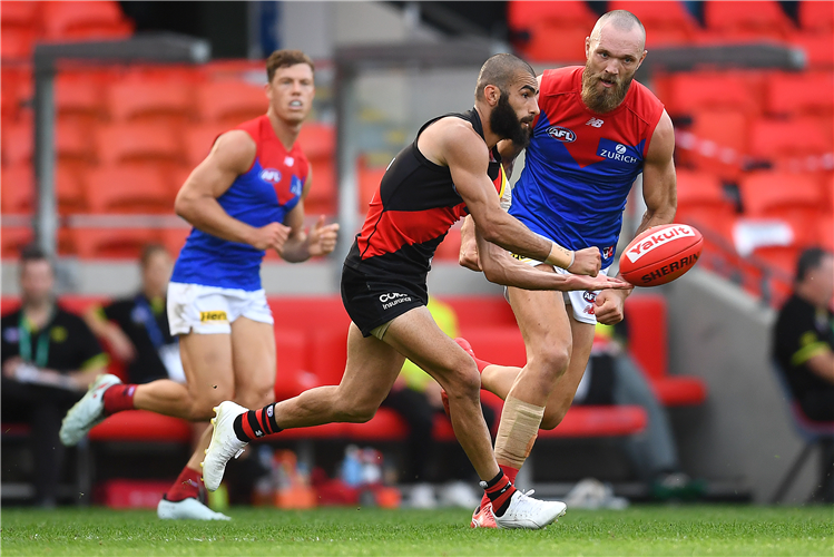 ADAM SAAD of the Bombers handballs during the round 18 AFL match between the Essendon Bombers and the Melbourne Demons at Metricon Stadium in Gold Coast, Australia.