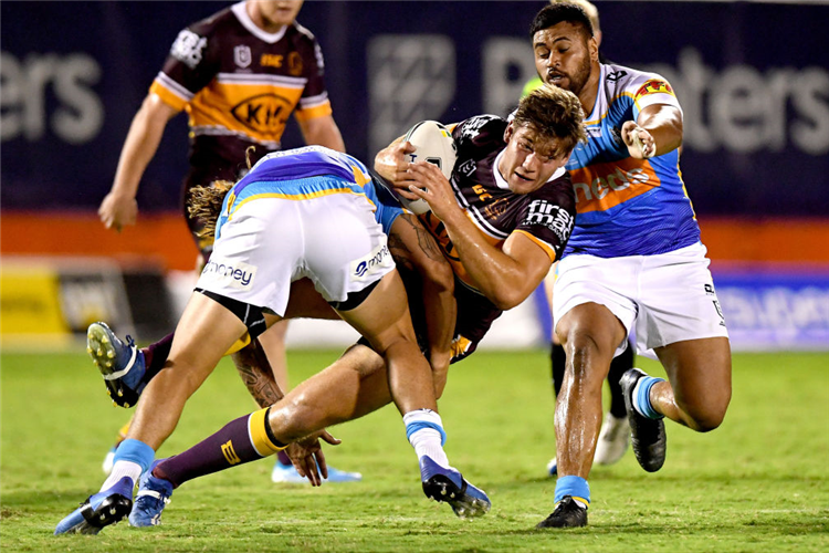 PATRICK CARRIGAN of the Broncos is tackled during the NRL Trial match between the Brisbane Broncos and the Gold Coast Titans at Redcliffe in Brisbane, Australia.