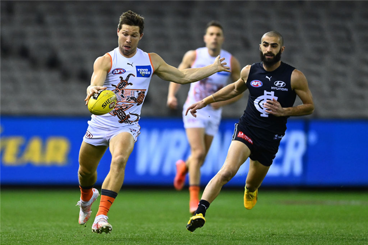 TOBY GREENE (L) of the Giants kicks during the AFL match between Carlton Blues and Greater Western Sydney Giants at Marvel Stadium in Melbourne, Australia.