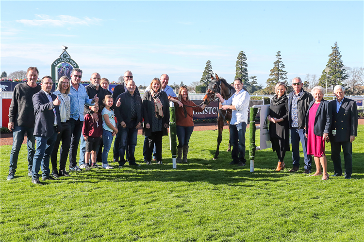 Sally McKay (brown top, holding horse) and the large group of owners involved with debutant winner Palmetto