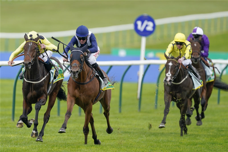 COMMISSIONING (blue cap) winning the Fillies' Mile at Newmarket in England.