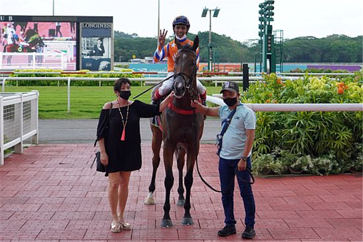 Jockey A'Isisuhairi Kasim celebrates his third consecutive victory of the day atop Entertainer, with trainer Donna Logan on hand.