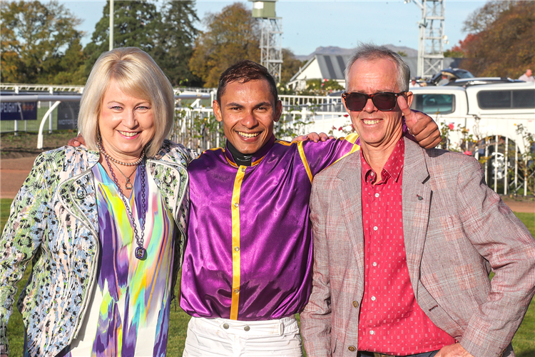 Jockey Kavish Chowdhoory poses with trainer Lance Robinson and his wife Christine after the win by Live Drama