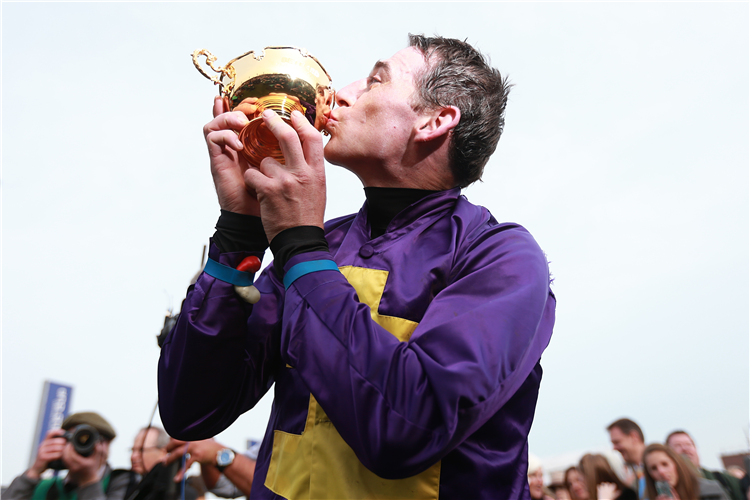 Jockey : DAVY RUSSELL celebrates with the Gold Cup trophy after winning the Betfred Cheltenham Gold Cup Chase on board Lord Windermere on Gold Cup Day, during the Cheltenham Festival. 