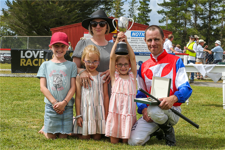 Jason Laking poses with his partner Lou and their three daughters Maddie (left) Hazel and Georgia (holding trophy) after the win by Camino Rocoso