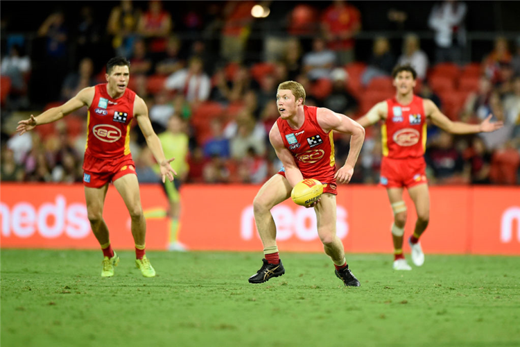 MATT ROWELL of the Suns handballs during the AFL match between the Gold Coast Suns and the Melbourne Demons at Metricon Stadium in Gold Coast, Australia.