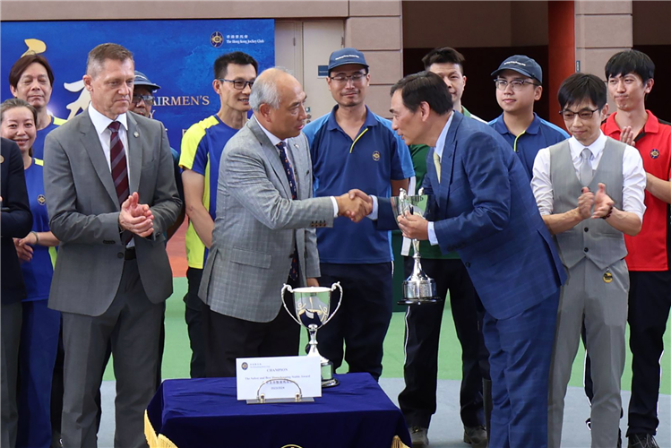 Trainer Michael Chang (right) receives the trophy for this season’s Safest and Best Housekeeping Stable Award from K L Cheng (left), The Hong Kong Jockey Club’s Head of Dual Site Stables Operations.