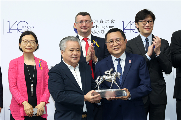 Owner Tung Moon Fai collects the trophy for Champion Griffin.