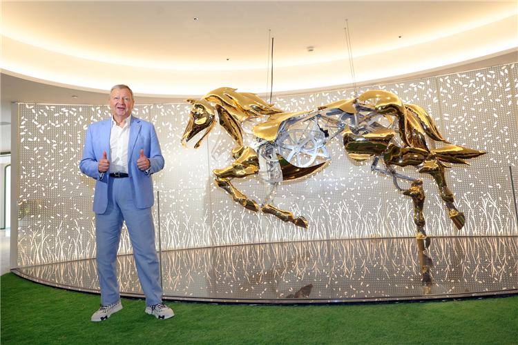 The Hong Kong Jockey Club’s Chief Executive Officer Winfried Engelbrecht-Bresges poses with the “mechanical galloping horse sculpture” by an American artist at the Champions Connection, an impressive sight to draw crowds. -