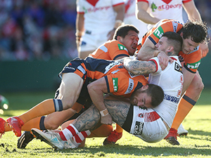 JOSH DUGAN of the Dragons is tackled during the NRL match between the St George Illawarra Dragons and the Newcastle Knights at UOW Jubilee Oval in Sydney, Australia.
