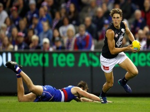 CHARLIE CURNOW of the Blues evades Zaine Cordy of the Bulldogs during the 2018 AFL match between the Western Bulldogs and the Carlton Blues at Etihad Stadium in Melbourne, Australia.