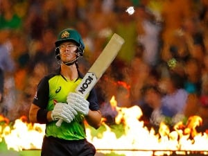 DARCY SHORT of Australia walks onto the field to bat through flames during game two of the International Twenty20 series between Australia and England at Melbourne Cricket Ground in Melbourne, Australia.