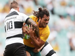 KARMICHAEL HUNT of the Wallabies is tackled during the match between the Australian Wallabies and the Barbarians at Allianz Stadium in Sydney, Australia.