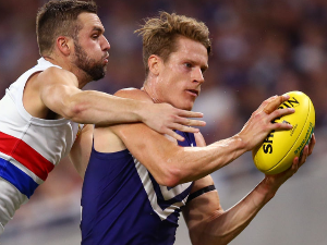 MATT TABERNER of the Dockers marks the ball against MATTHEW SUCKLING of the Bulldogs during the AFL match between the Fremantle Dockers and the Western Bulldogs at Optus Stadium in Perth, Australia.