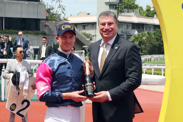 潘頓從香港賽馬會賽馬業務及營運總監利達賢手中接過紀念香檳。