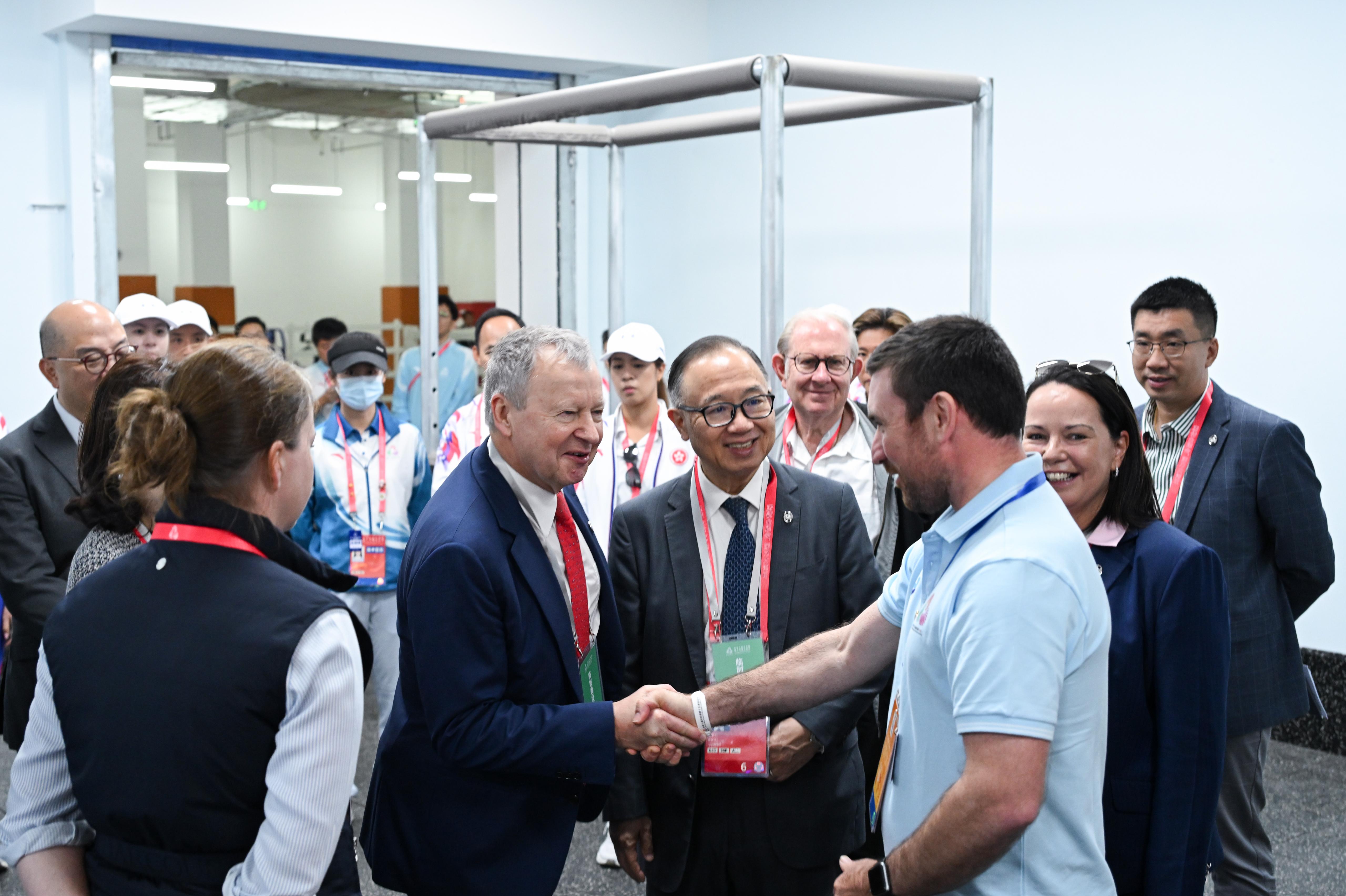 香港賽馬會主席廖長江（左三）、行政總裁應家柏（左二）參觀由馬會支持十五運會馬術賽事而設立的馬醫院及釘甲房等，為在賽事期間提供專業支援的馬會同事打氣