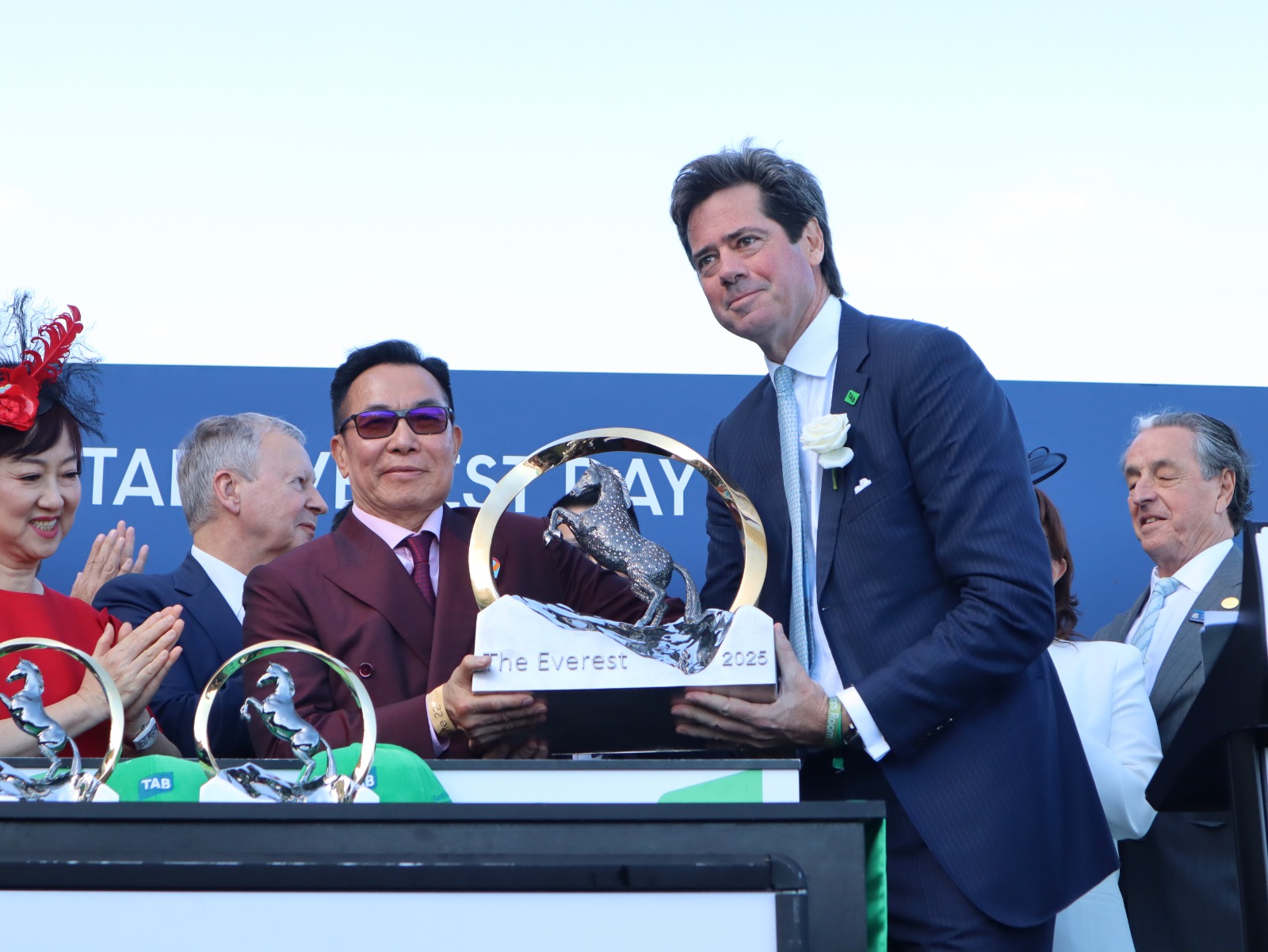 「嘉應高昇」的馬主團體代表梁錫光，在頒獎禮上接過珠穆朗瑪峰錦標冠軍獎盃