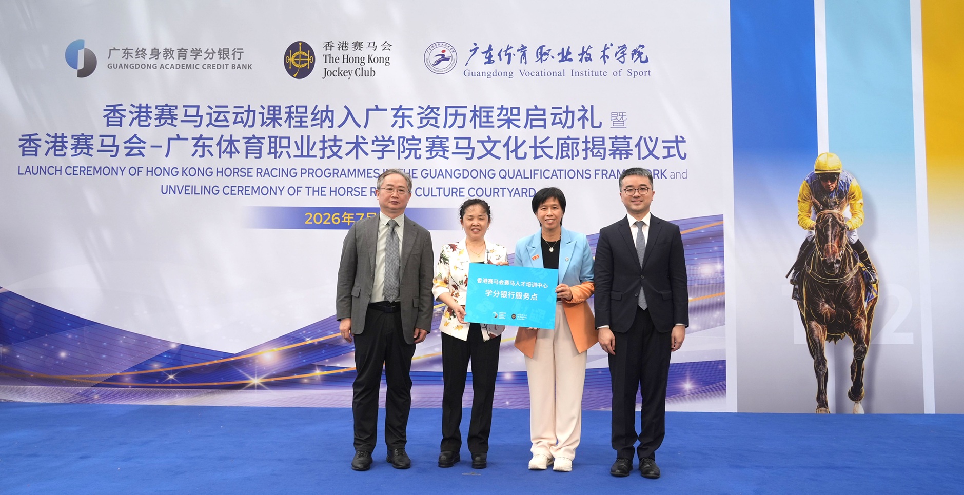 在香港特別行政區政府教育局副局長施俊輝博士（右一）及廣東省教育廳交流合作處（港澳台辦）處長李金俊（左一）的見證下，廣東開放大學學分銀行管理中心主任潘美意（左二）向香港賽馬會頒發牌匾，標誌著香港賽馬證書課程正式納入廣東終身資歷框架名冊，並由馬會賽馬人才培訓主管暨見習騎師學校校長陳念慈（右二）代表接受
